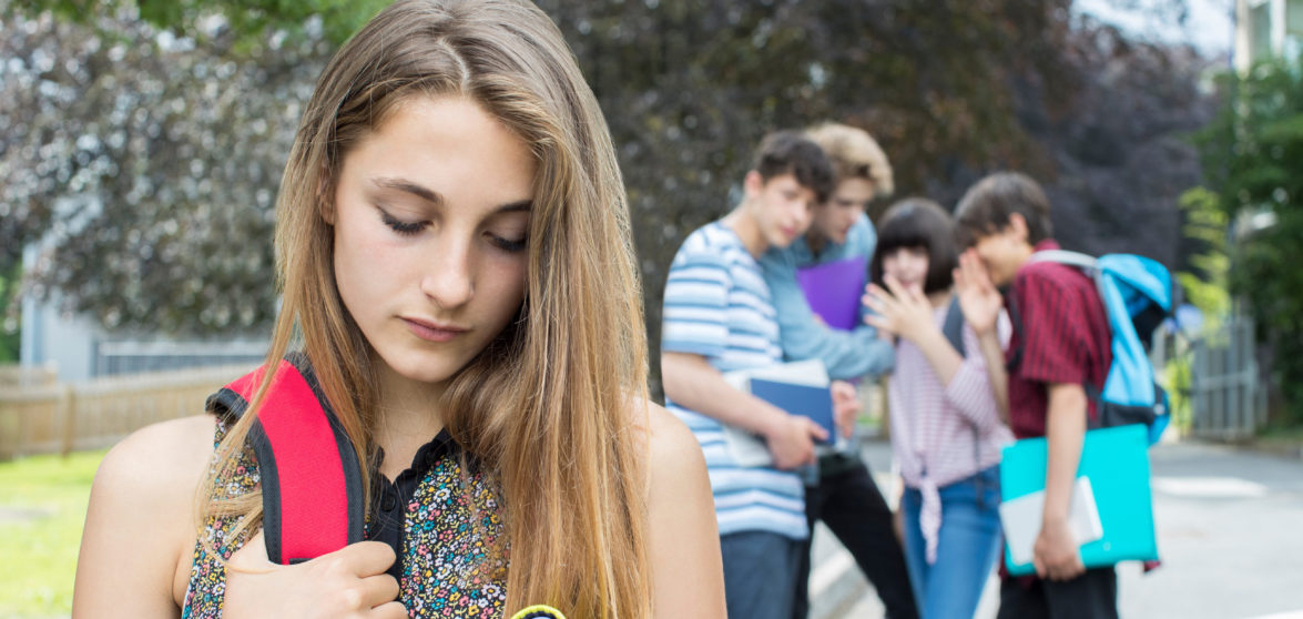 teens talking behind a teen girl's back