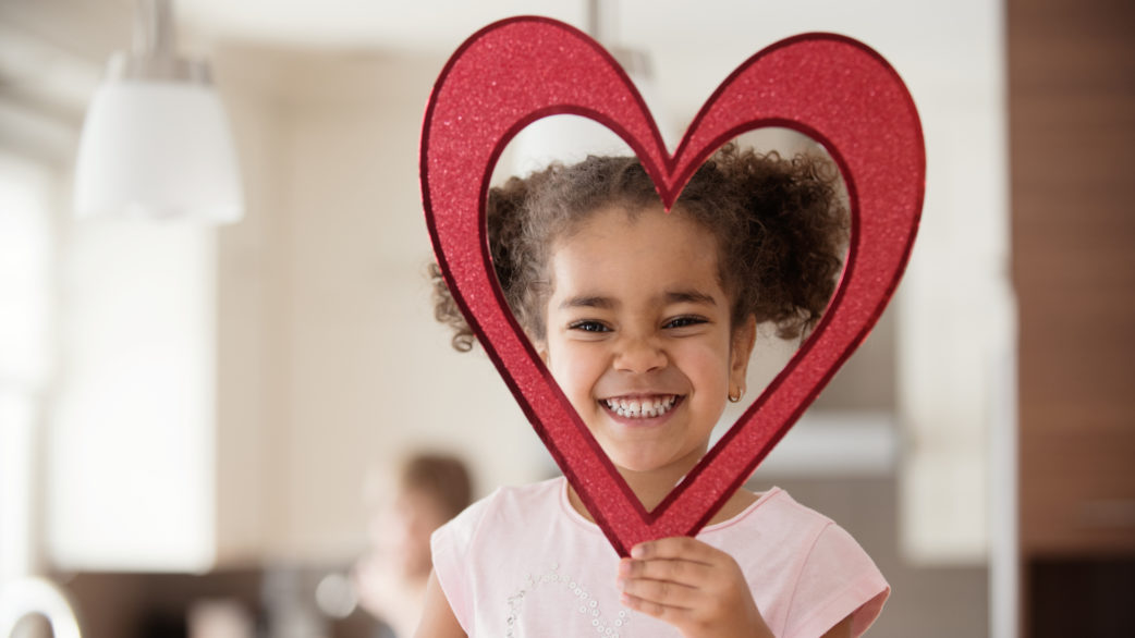 girl holding up heart