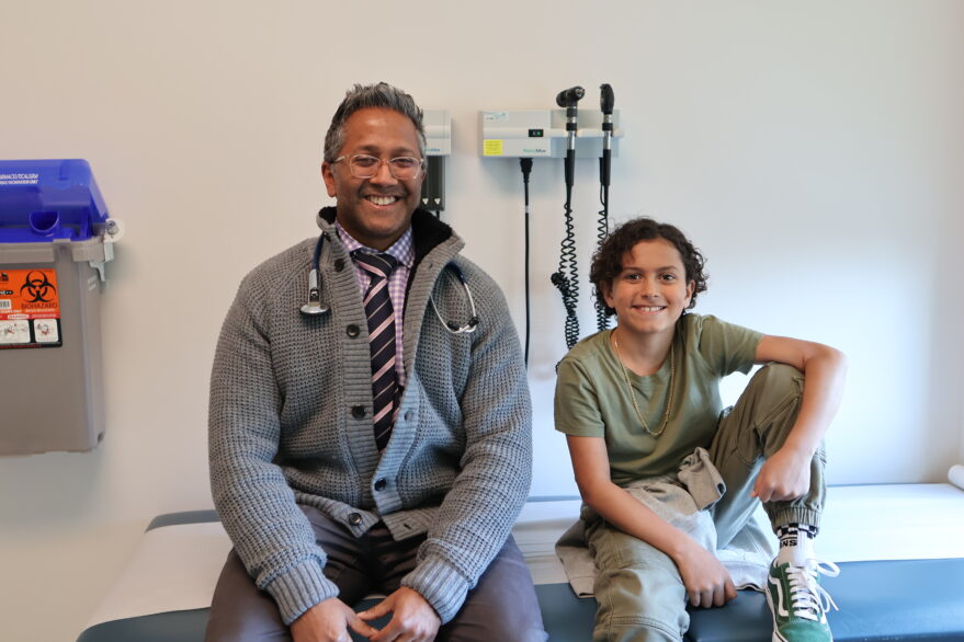 Young boy with a doctor smiling in a hospital room setting