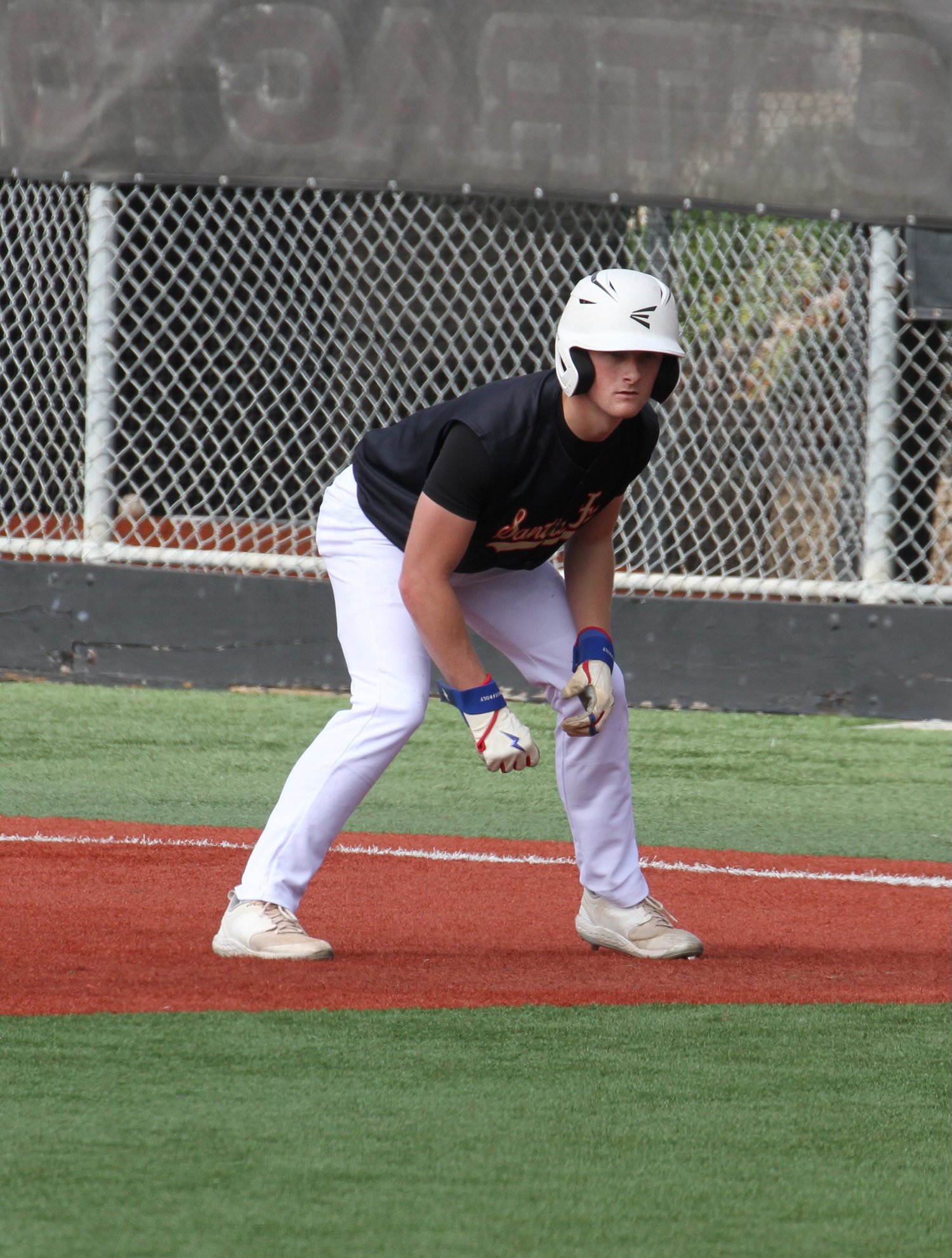 Micah on the baseball field, ready to take off from base in his uniform