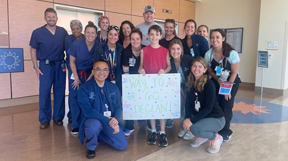 Declan standing with a group of hospital staff in a hallway