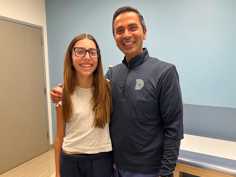 Divya smiling with orthopedic spine surgeon V. Salil Upasani, MD, at a follow-up visit at Rady Children's