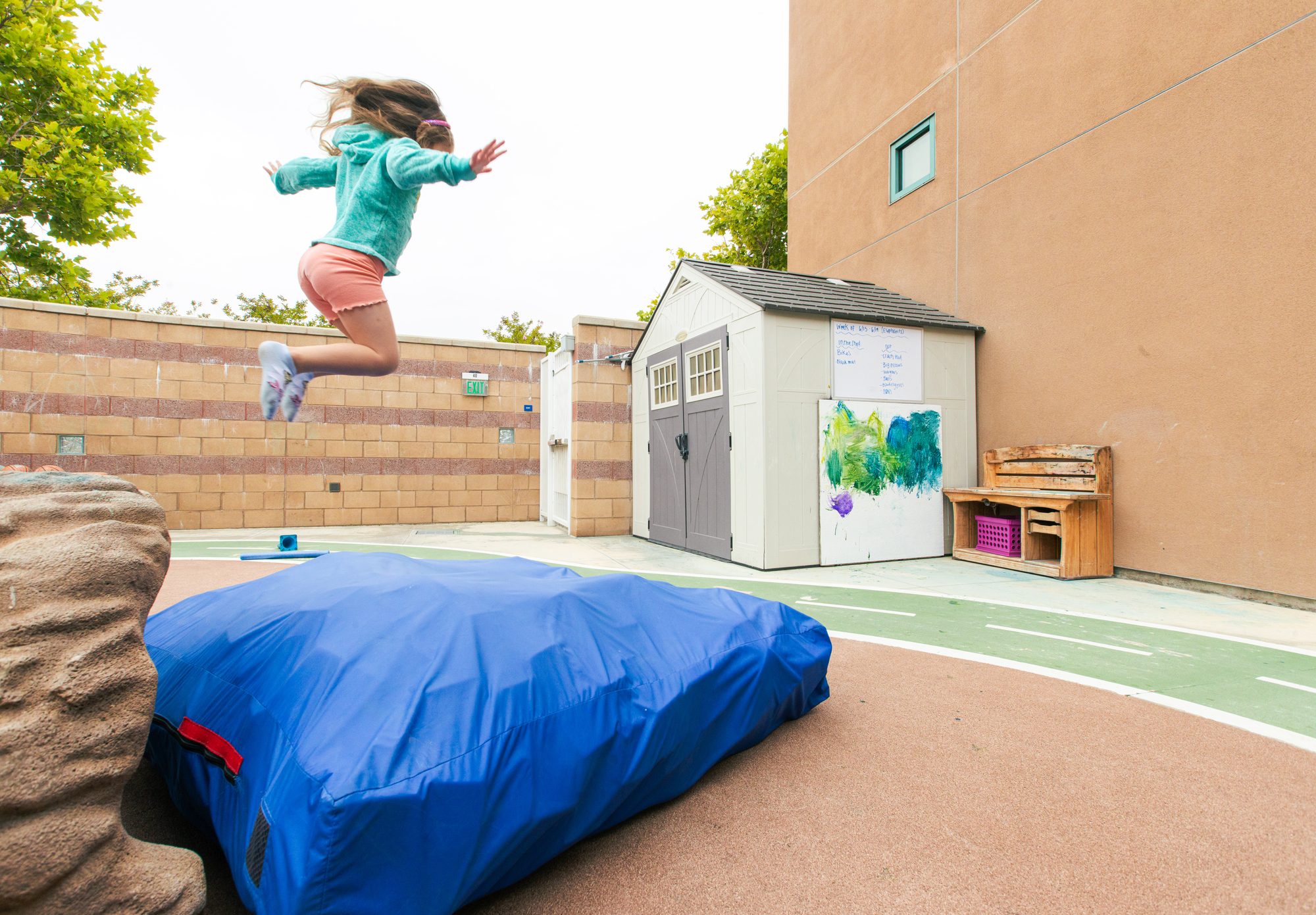 Child jumping onto a crash pad on the Alexa's PLAYC playground