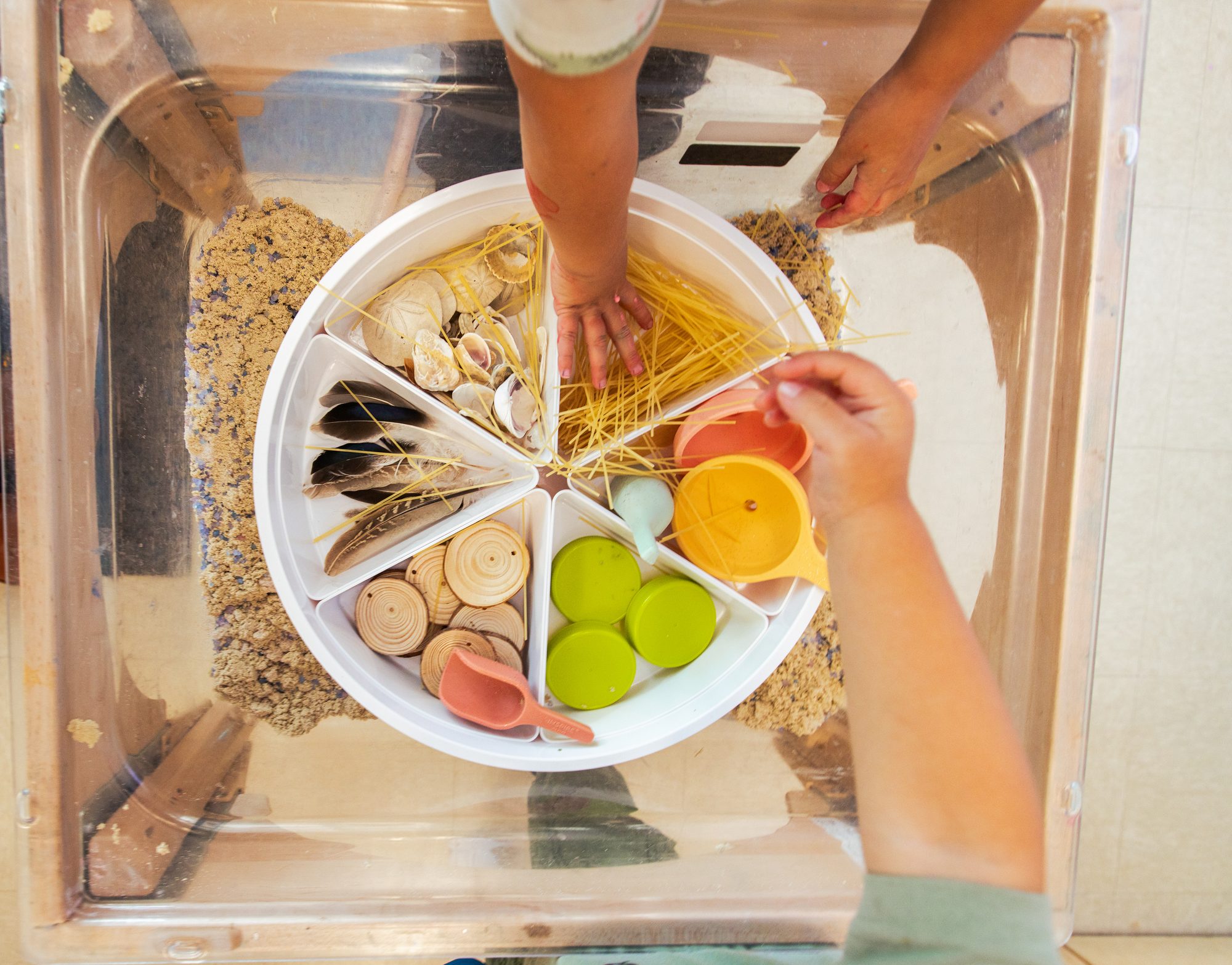 Child playing with a sensory sand tray at Alexa's PLAYC