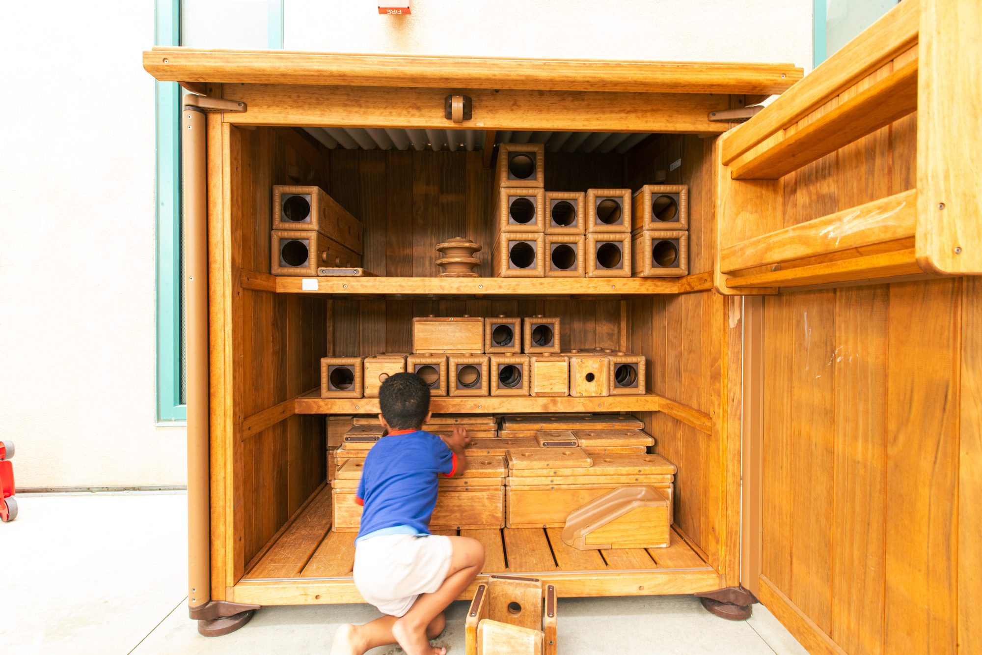 Child building with wooden blocks at Alexa's PLAYC