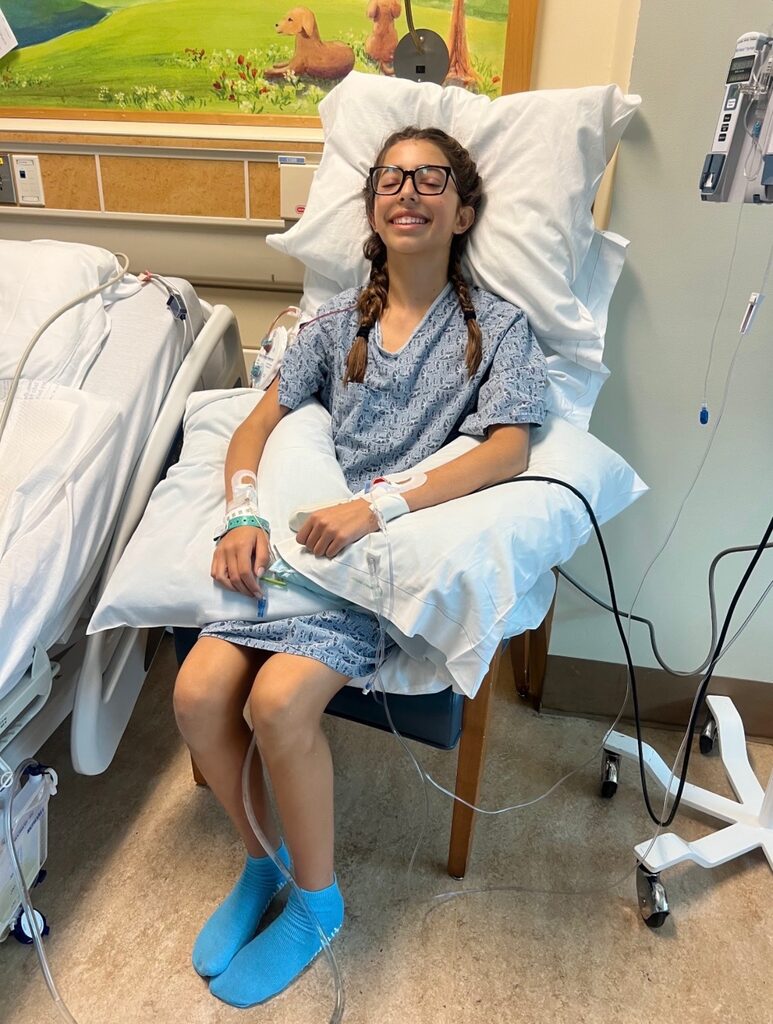 Divya smiling while recovering in the hospital after spinal fusion surgery